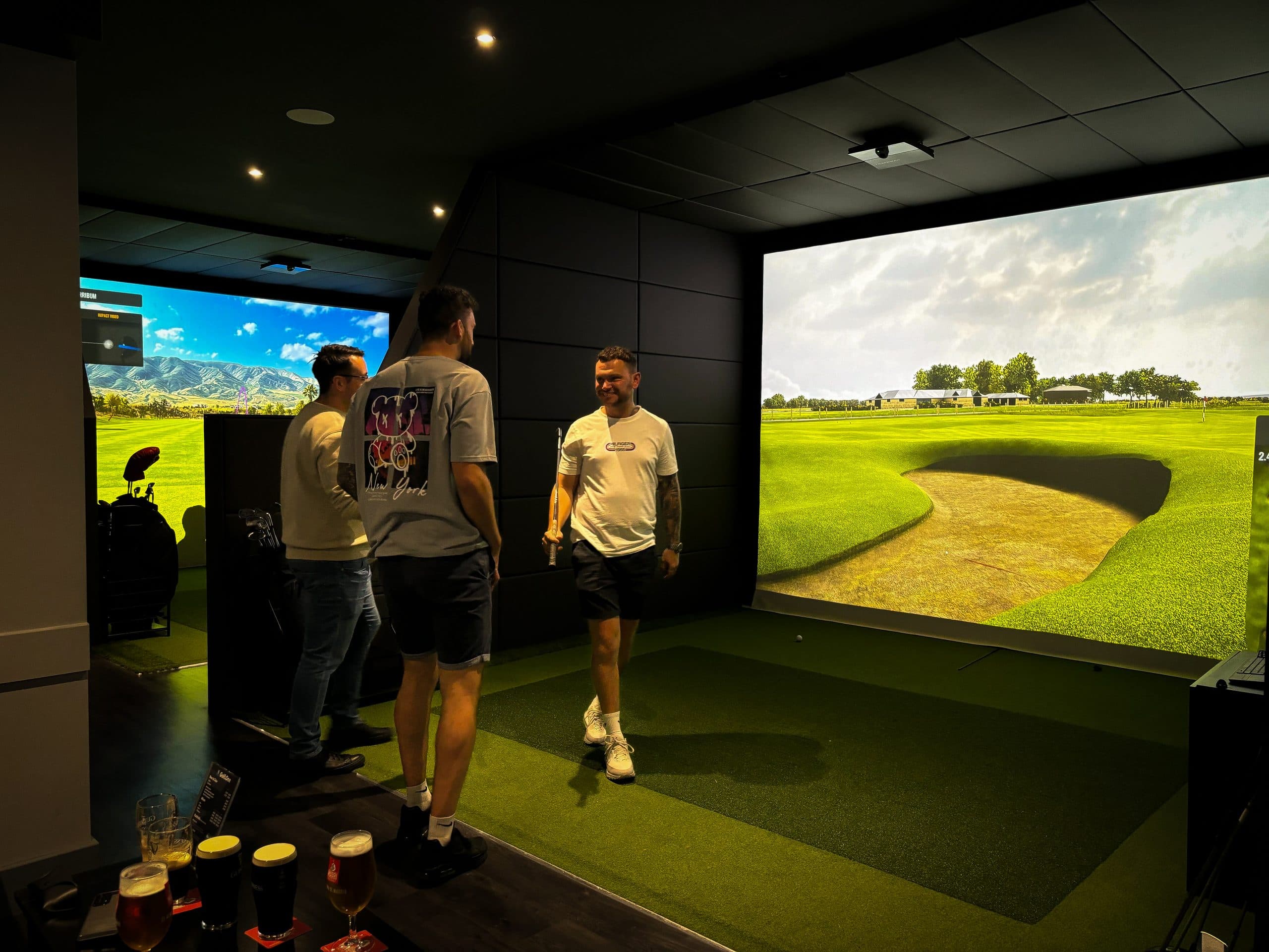 Friends playing a round in a Golf.One simulator bay