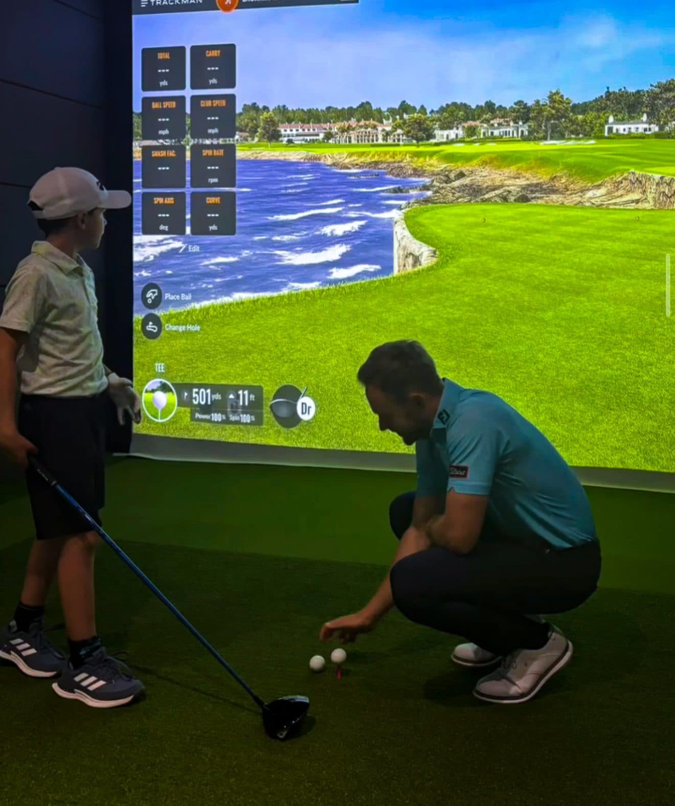 Our coach setting up a junior golfer in a Trackman bay