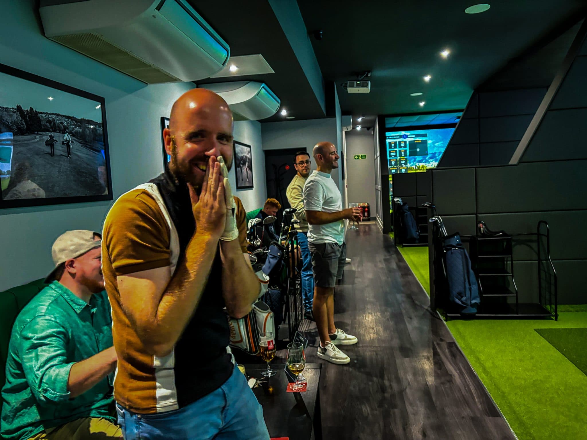 A group celebrating in a Golf.One simulator bay